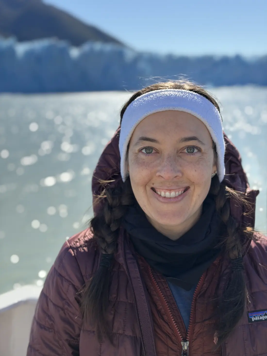 Ashley smiling outdoors in a snowy mountain landscape